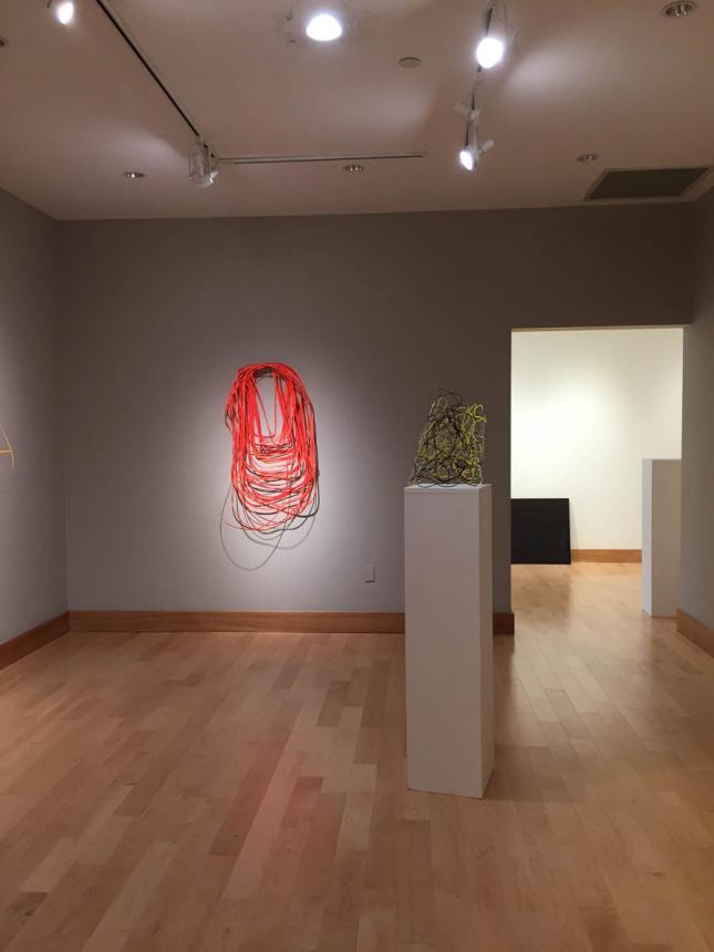 Gallery room view with one wall piece and one piece on a plinth in the frame